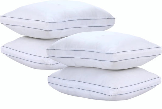 Four white pillows with thin gray stripes on a light gray background
